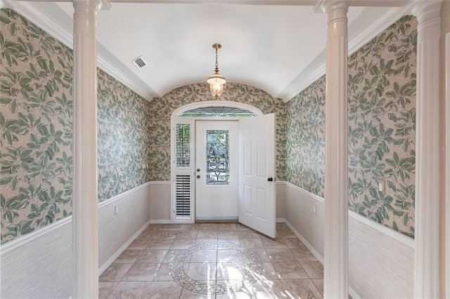 entrance foyer featuring wallpapered walls, decorative columns, vaulted ceiling, and wainscoting