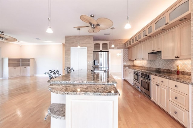 kitchen with ceiling fan, appliances with stainless steel finishes, a sink, and decorative backsplash