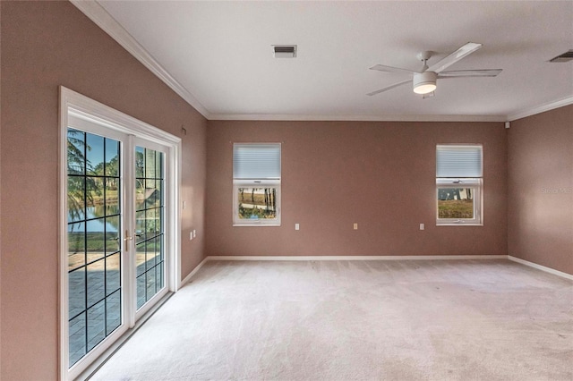 empty room with light carpet, baseboards, visible vents, ceiling fan, and ornamental molding