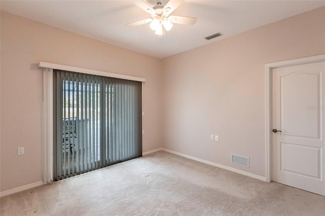 spare room with a ceiling fan, carpet, and visible vents