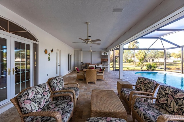 sunroom with french doors and a ceiling fan