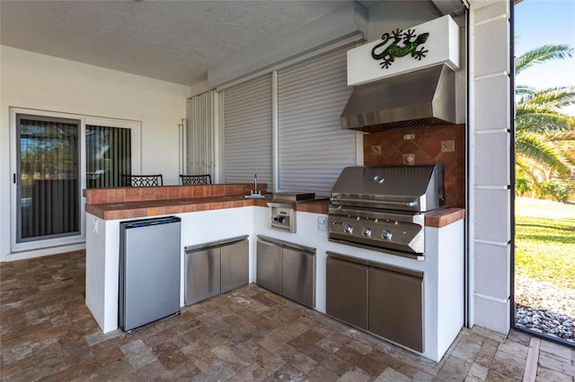 view of patio / terrace featuring outdoor wet bar, a sink, a grill, and area for grilling