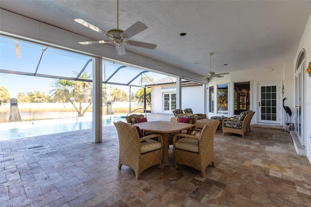 view of patio with ceiling fan, outdoor dining space, a lanai, and an outdoor pool