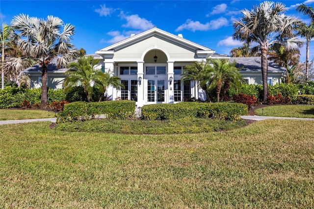 view of front of home with french doors, a front yard, and stucco siding