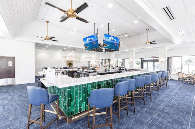 bar featuring dark colored carpet, a raised ceiling, a ceiling fan, and recessed lighting