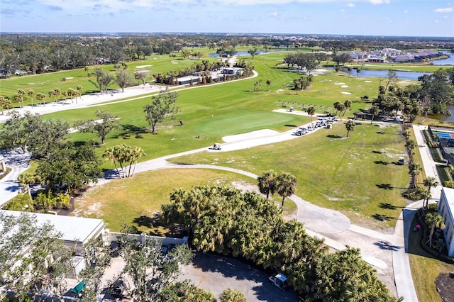 drone / aerial view featuring golf course view and a water view