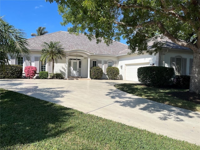 view of front of home with a garage and a front lawn