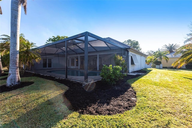 back of house featuring a lanai, a patio area, and a yard