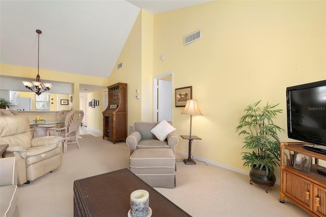 carpeted living room featuring a chandelier and high vaulted ceiling