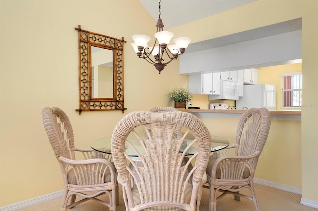 dining area featuring an inviting chandelier, light colored carpet, and lofted ceiling