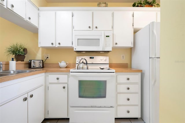 kitchen with sink, white appliances, and white cabinets