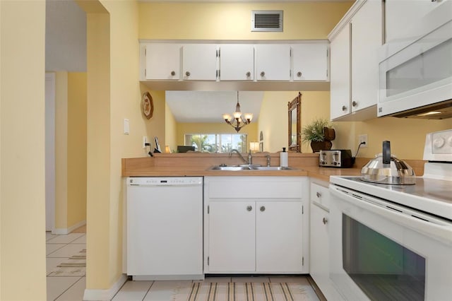 kitchen with sink, a chandelier, pendant lighting, white appliances, and white cabinets