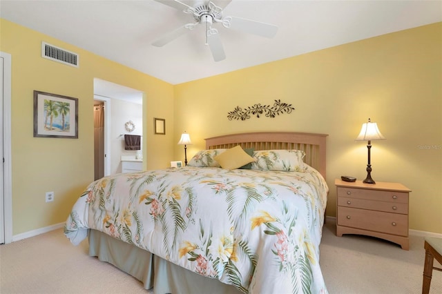 carpeted bedroom with ceiling fan and ensuite bath