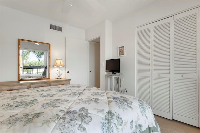 carpeted bedroom with ceiling fan and a closet