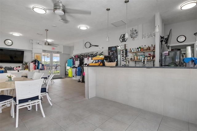 interior space featuring light tile patterned floors, a textured ceiling, and ceiling fan