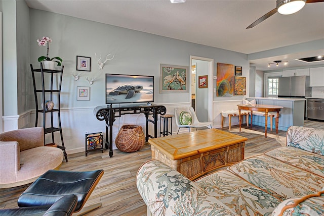 living room with ceiling fan and light wood-type flooring