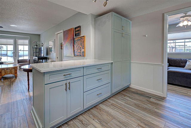 kitchen with plenty of natural light, light hardwood / wood-style floors, and kitchen peninsula