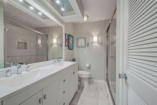 bathroom featuring vanity, toilet, and a shower with shower door