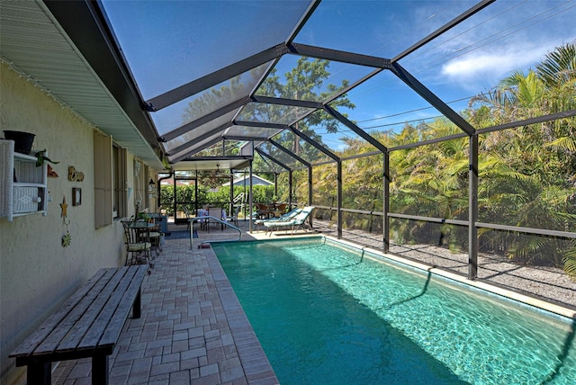 view of pool with a patio and glass enclosure