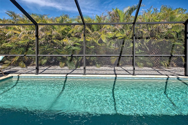 view of swimming pool with glass enclosure