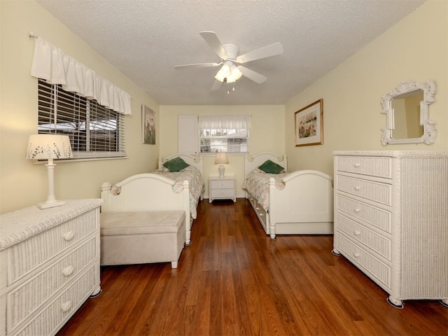 bedroom with ceiling fan, dark hardwood / wood-style flooring, and a textured ceiling