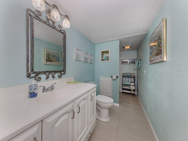 bathroom with tile patterned flooring, vanity, toilet, and a textured ceiling