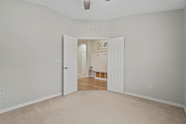 unfurnished bedroom featuring vaulted ceiling, light colored carpet, and ceiling fan