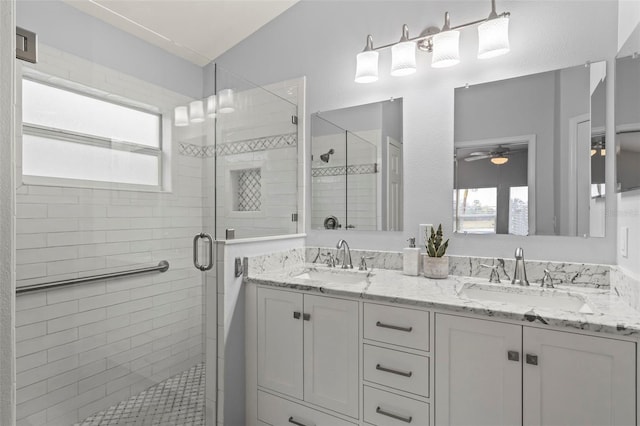 bathroom with ceiling fan, vanity, and a shower with door