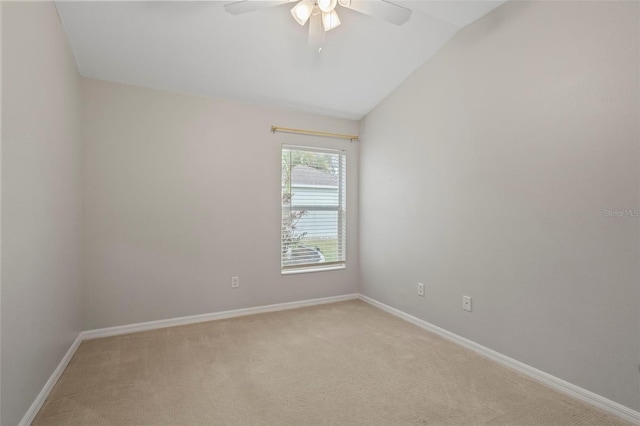 empty room with ceiling fan, light colored carpet, and vaulted ceiling