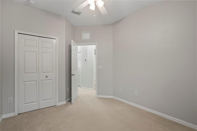 unfurnished bedroom with light colored carpet, ceiling fan, and a closet