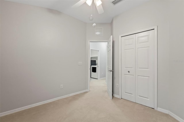 unfurnished bedroom featuring lofted ceiling, light colored carpet, a closet, and ceiling fan