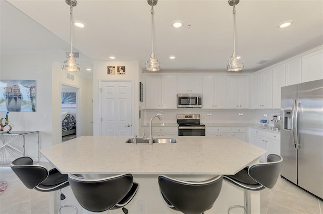 kitchen featuring white cabinetry, sink, stainless steel appliances, and hanging light fixtures