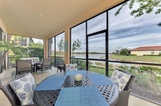 sunroom featuring a water view