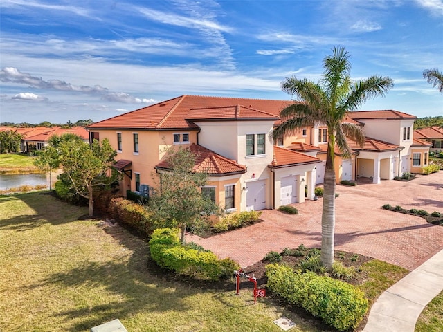 mediterranean / spanish house with a garage and a front yard