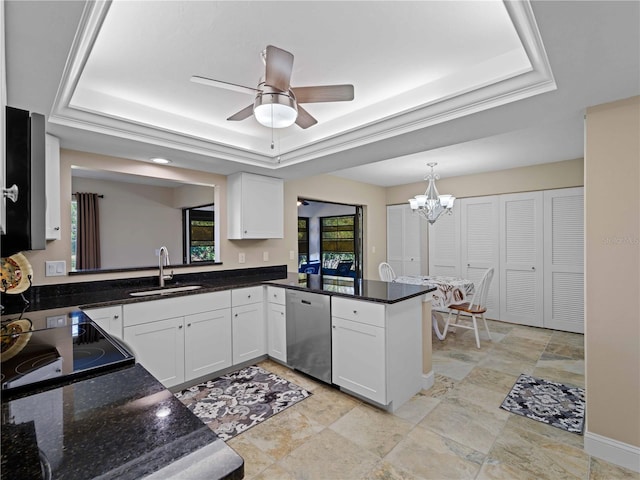 kitchen with a tray ceiling, dishwasher, sink, and white cabinets