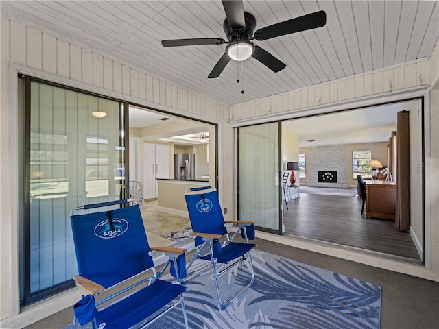 sunroom / solarium featuring a fireplace and ceiling fan