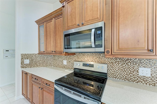 kitchen with tasteful backsplash, appliances with stainless steel finishes, and light tile patterned floors