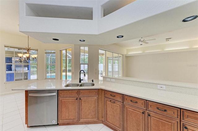 kitchen with sink, hanging light fixtures, light tile patterned floors, dishwasher, and ceiling fan with notable chandelier