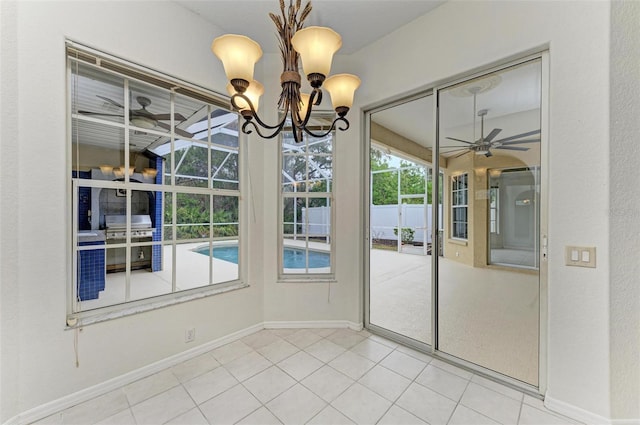 interior space with ceiling fan with notable chandelier and tile patterned floors