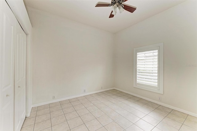 spare room with ceiling fan and light tile patterned floors