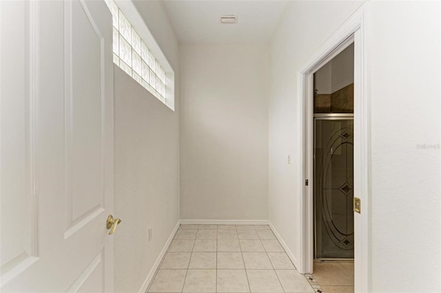 hallway with light tile patterned floors and washer / dryer