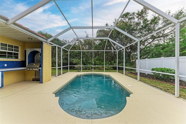 view of pool with a lanai, grilling area, and a patio