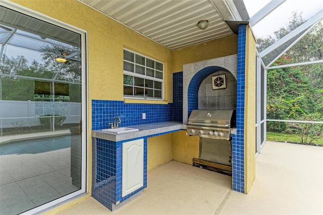 view of patio / terrace with an outdoor kitchen, a grill, a lanai, and sink