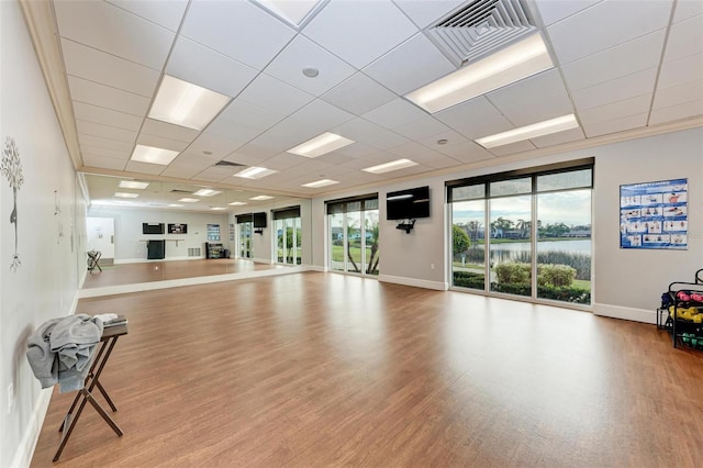 exercise room with wood-type flooring and a paneled ceiling