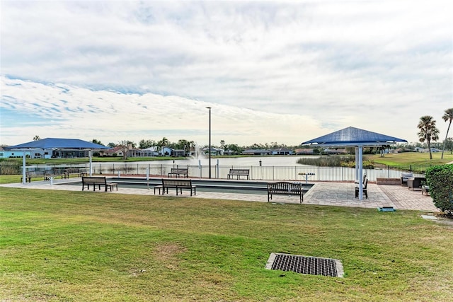 view of community with a lawn and a water view