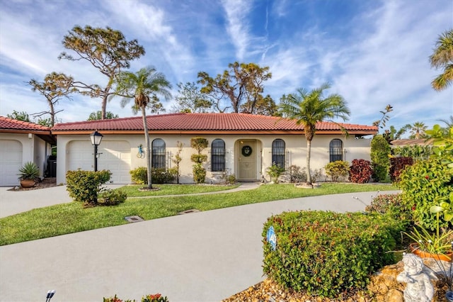 mediterranean / spanish-style house featuring a garage and a front yard