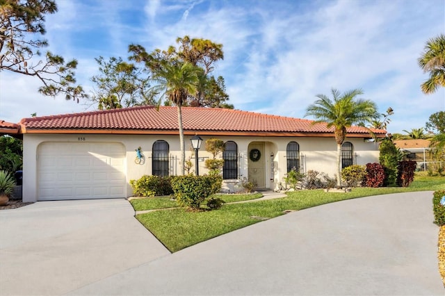 mediterranean / spanish-style house with a garage and a front yard