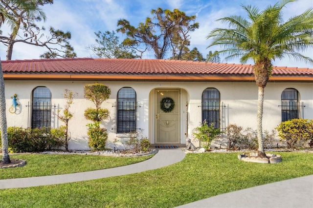 mediterranean / spanish-style home with a front yard