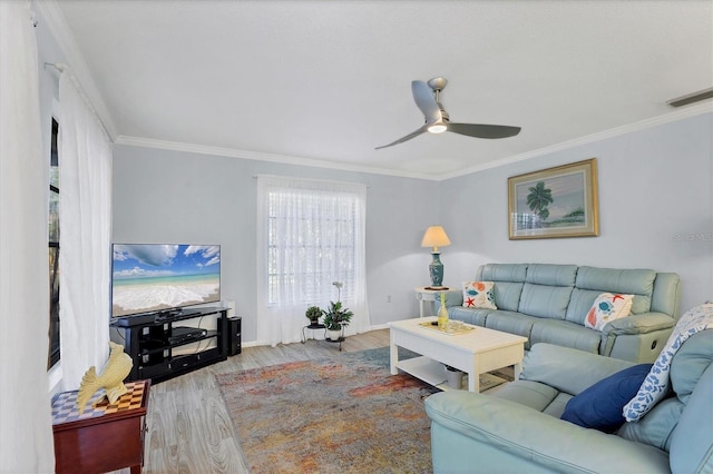 living room with hardwood / wood-style flooring, ornamental molding, and ceiling fan