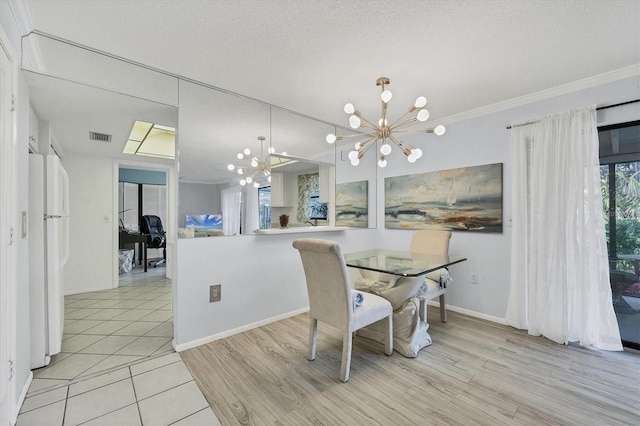 dining space featuring an inviting chandelier, ornamental molding, light hardwood / wood-style floors, and a textured ceiling